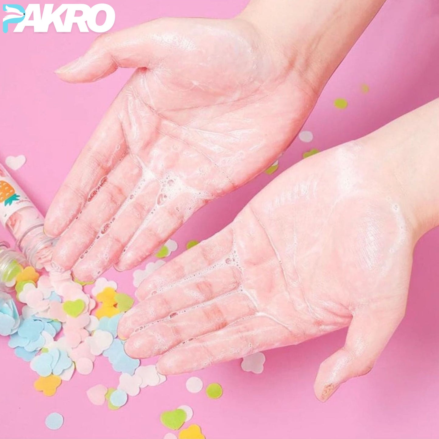 Paper soap is small and easy to carry a small flower shaped piece of paper soap can wash your hands water can be completely dissolved is a good partner for your health clean. Made of high-quality environmental materials and pure natural plant extracts the soap sheet is safe with no bad effects. Hands with soap bubbles and colorful confetti on a pink background, featuring the brand 'AKRO'.