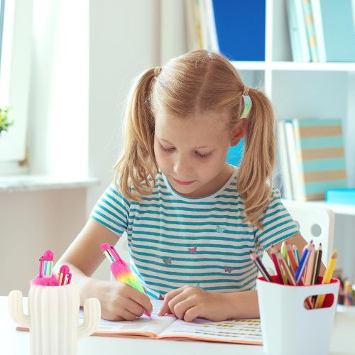 Young girl with pigtails coloring at a table with colorful markers and crayons.