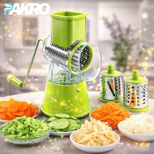 Green manual vegetable chopper with various sliced vegetables on a kitchen counter.