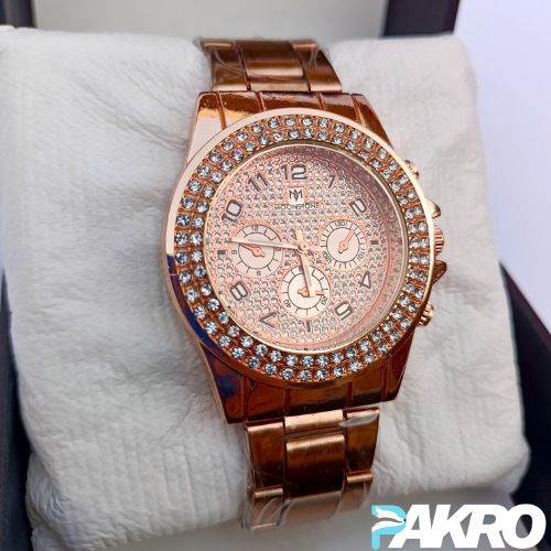 Rose gold watch with diamond-studded face on a white cushion, brand 'PAKRO' visible.