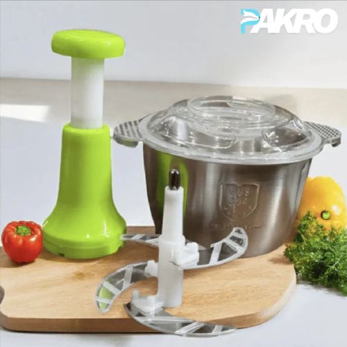 Green kitchen tool on a wooden cutting board with vegetables in the background, featuring the brand 'PAKRO'.