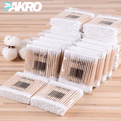 Multiple packages of cotton swabs with visible 'PAKRO' branding on a wooden surface.