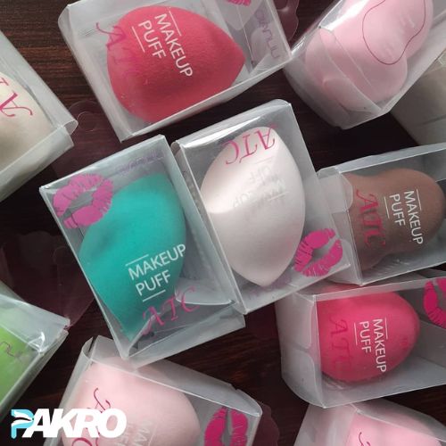 Makeup puffs in clear packaging with visible brand name on a wooden surface.