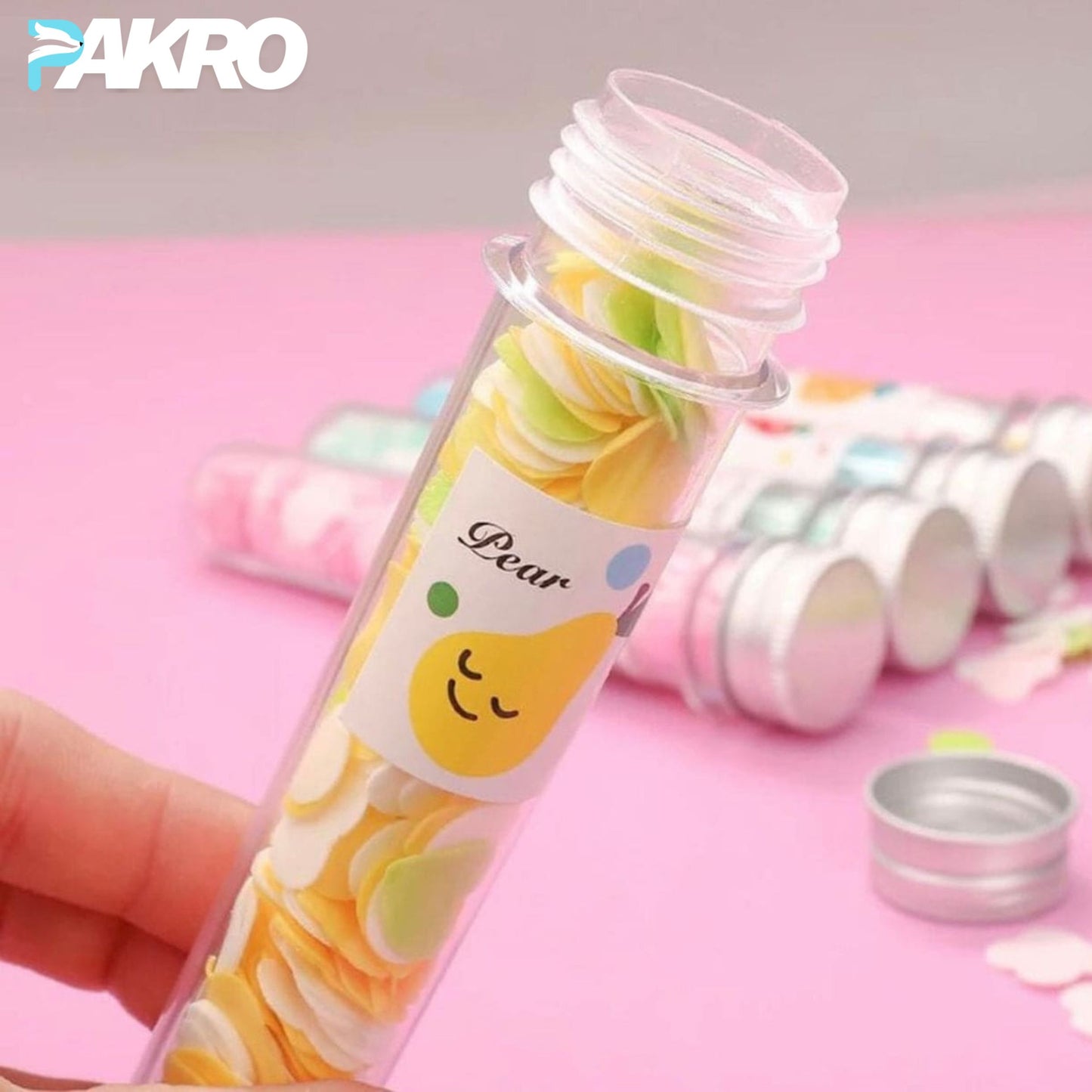 Colorful round candies in a transparent tube with 'Pear' label, held by a hand on a pink background. Fruit Paper Soap - Scented Tube Soap - Tube Paper Soap With Metal Cap