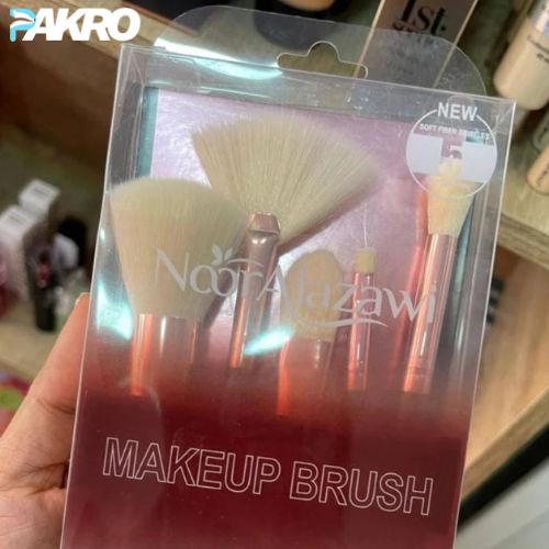 Packaged makeup brushes with 'Noo Taazawi' branding held by a hand.