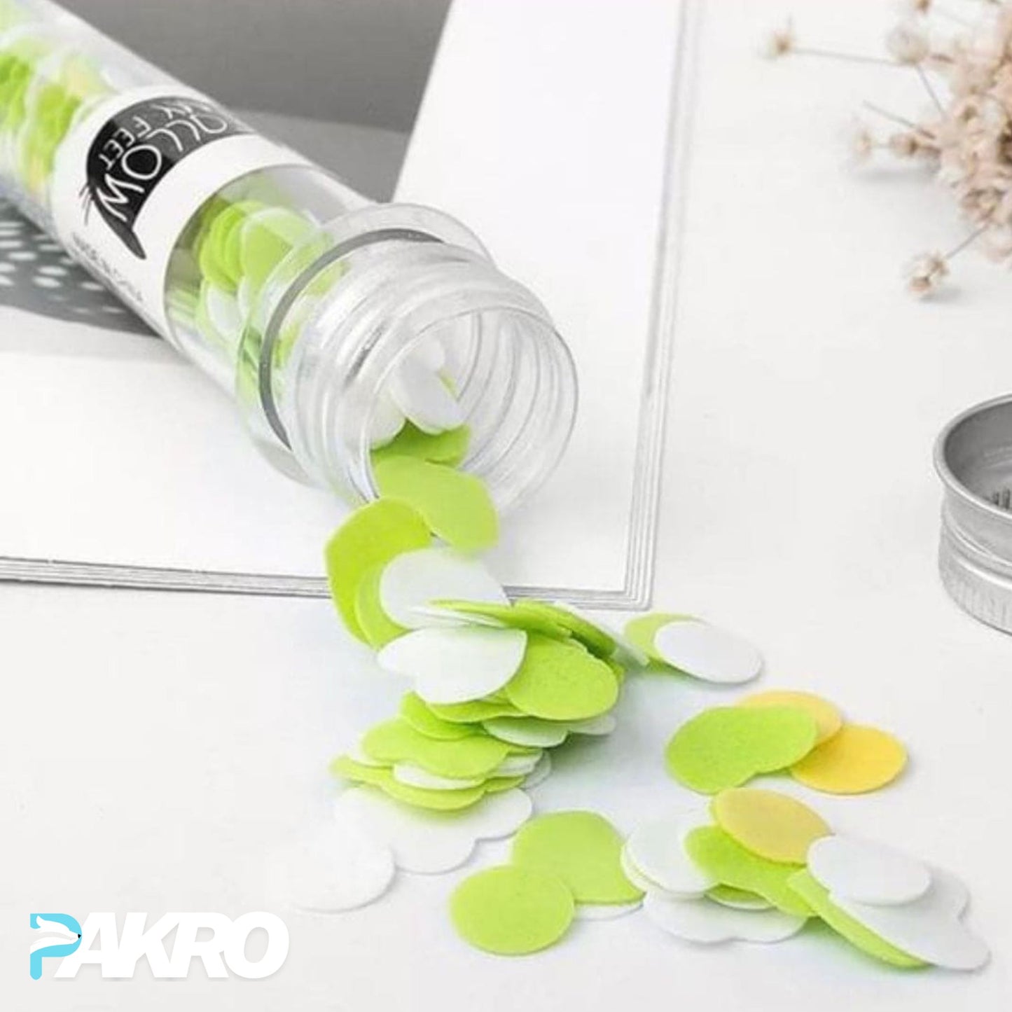 Green and white paper flower petals spilling out of a transparent container labeled 'PAKRO' on a light, Fruit Paper Soap - Scented Tube Soap - Tube Paper Soap With Metal Capbackground.