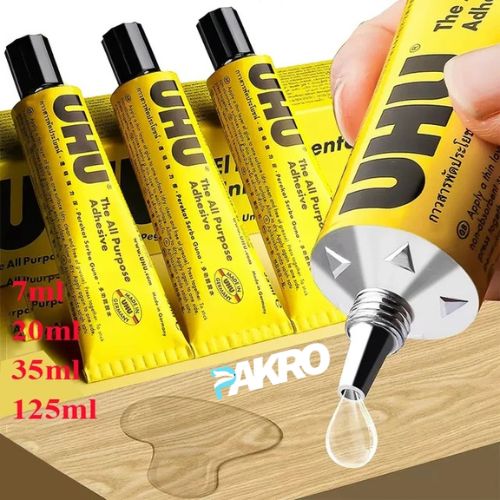 UHU glue sticks and a dropper on a wooden surface with 'PAKRO' branding.