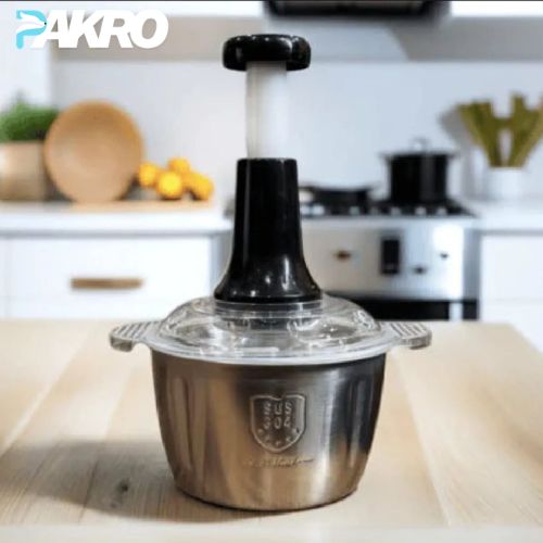 Stainless steel kitchen tool with black top on a wooden surface, brand 'PAKRO' visible
