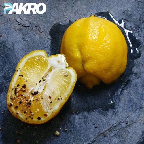 Two lemons, one sliced, on a dark surface with 'PAKRO' branding.