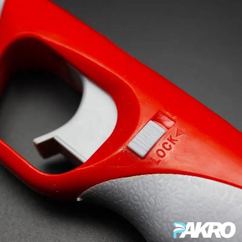 Close-up of a red and gray tool with 'PAKRO' branding on a dark background