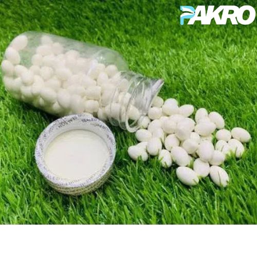 White granules spilling from a transparent container on green grass with 'PAKRO' branding.