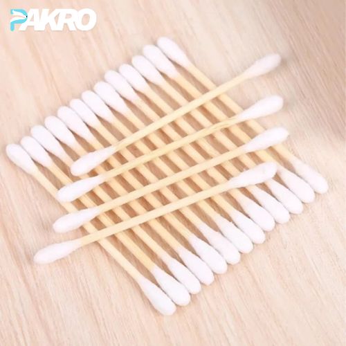Cotton swabs with wooden sticks on a light wooden surface, branded 'PAKRO'.