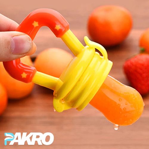 Orange baby fruit pouch with a yellow lid held by a hand, with fruits in the background, and 'PAKRO' branding.