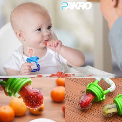 Baby using a blue pacifier with fruit inside, surrounded by oranges on a wooden surface. Baby Fruit Pacifier Infant Nipple Food Feeder