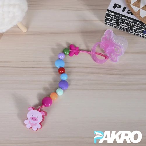 Colorful baby teething necklace with a pink pacifier holder on a wooden surface, branded 'PAKRO'.